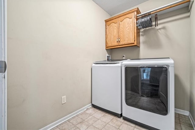 laundry room featuring cabinet space, baseboards, and separate washer and dryer