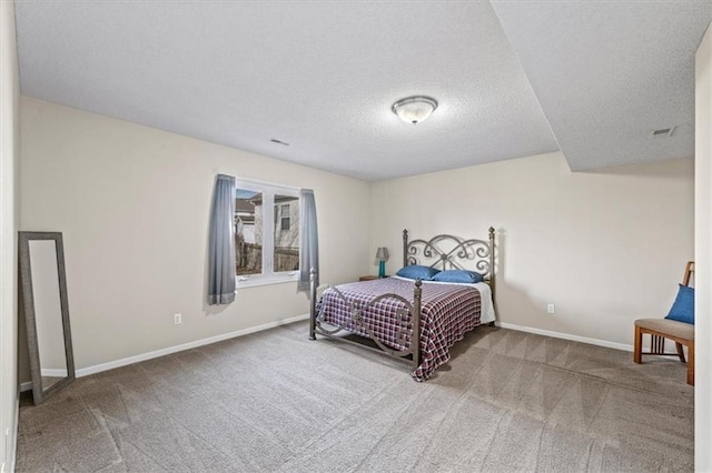 bedroom featuring a textured ceiling, carpet floors, visible vents, and baseboards