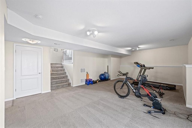 workout area with visible vents, light carpet, and baseboards