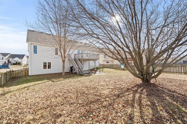 view of yard featuring a deck, stairway, and a fenced backyard