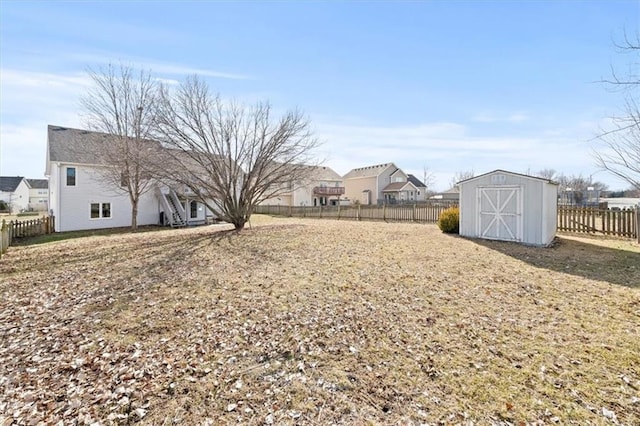 view of yard with a storage unit, an outdoor structure, and a fenced backyard