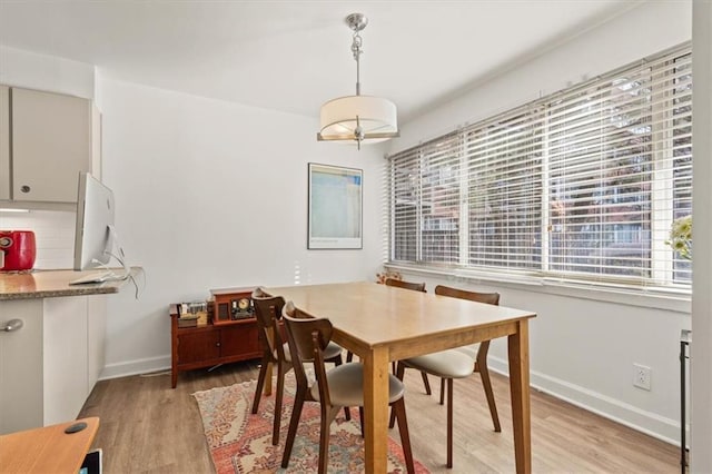 dining area with light wood finished floors and baseboards