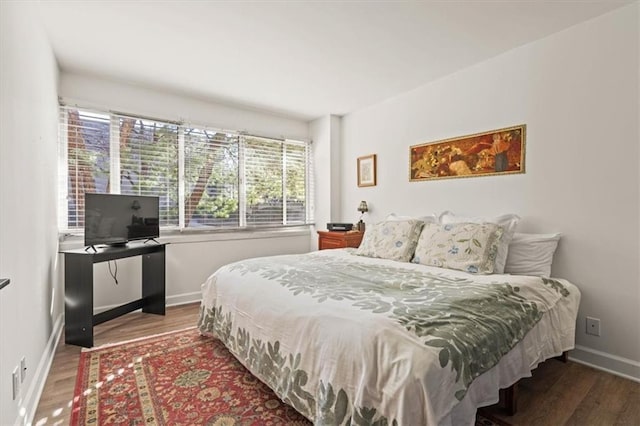 bedroom with wood finished floors and baseboards