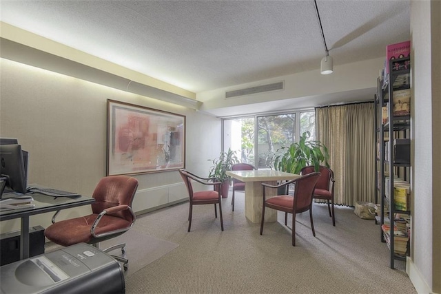 carpeted home office featuring visible vents and a textured ceiling