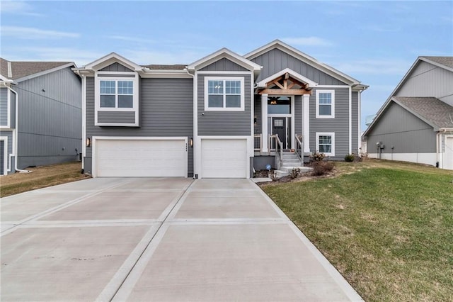 bi-level home featuring a garage, concrete driveway, a front lawn, and board and batten siding