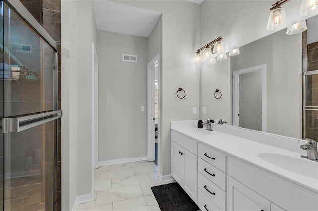 bathroom with marble finish floor, a sink, visible vents, and baseboards