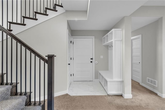 mudroom featuring light carpet, marble finish floor, visible vents, and baseboards