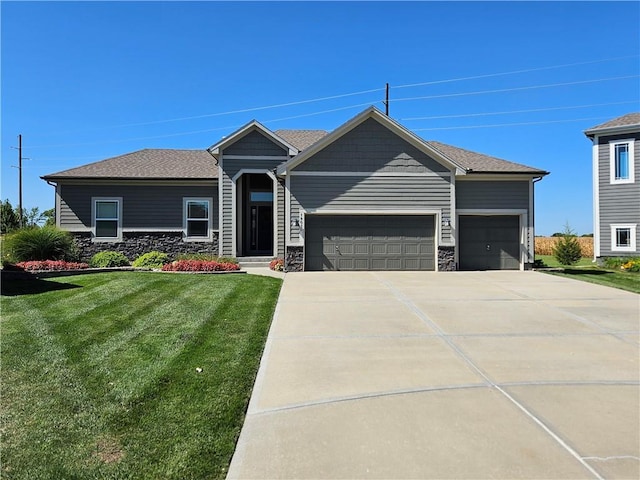 ranch-style house featuring an attached garage, a shingled roof, concrete driveway, stone siding, and a front lawn