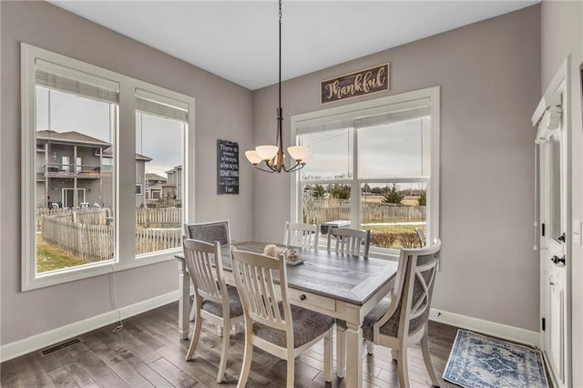 dining room featuring plenty of natural light, baseboards, and wood finished floors