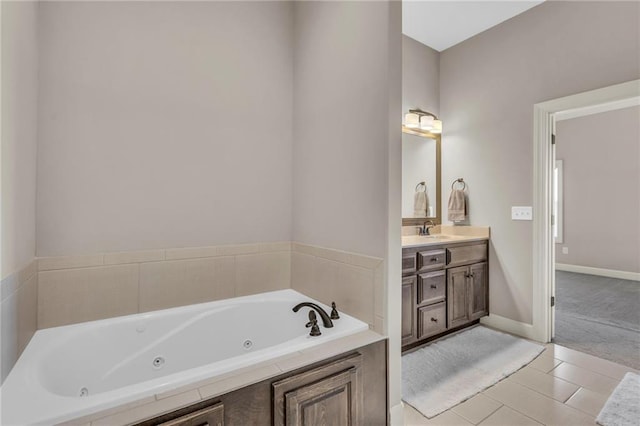 full bathroom featuring a whirlpool tub, tile patterned flooring, baseboards, and vanity