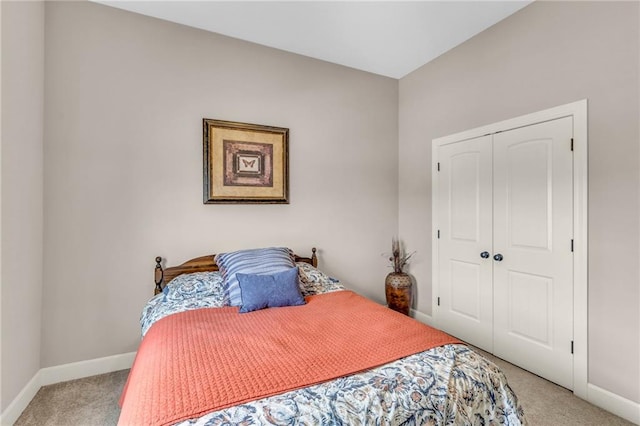 bedroom with a closet, light carpet, and baseboards