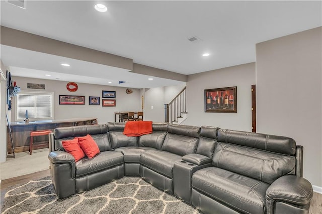 living room featuring recessed lighting, indoor bar, stairway, and wood finished floors