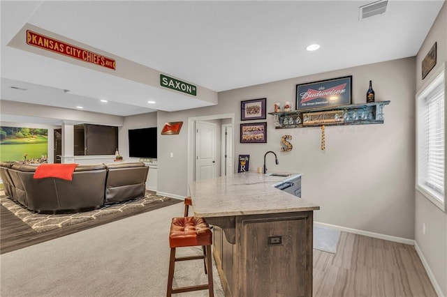 interior space featuring light stone countertops, baseboards, visible vents, and a sink