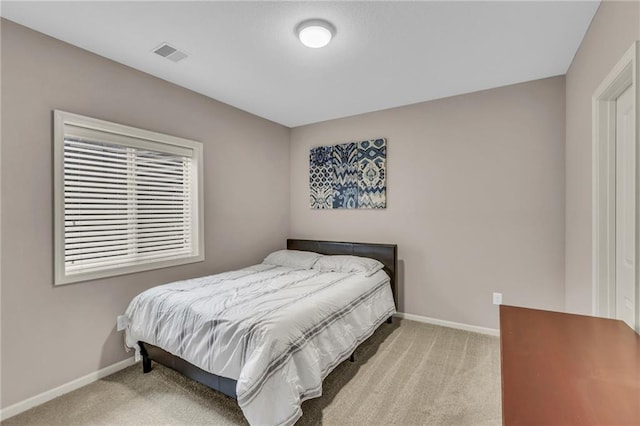 carpeted bedroom with visible vents and baseboards