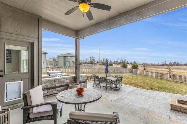 view of patio with an outdoor kitchen, a ceiling fan, outdoor dining space, a grill, and a fenced backyard