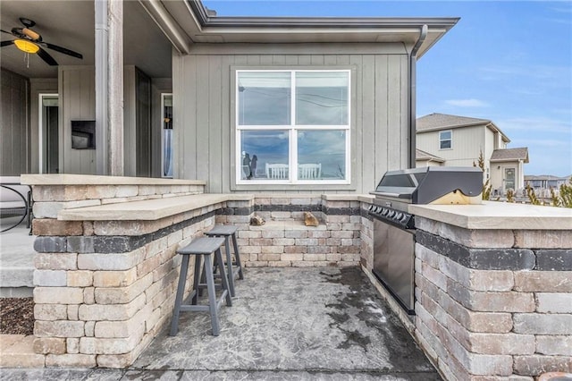 view of patio with a grill, an outdoor kitchen, and a ceiling fan