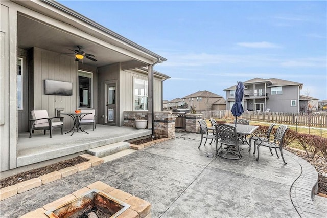 view of patio with an outdoor fire pit, a ceiling fan, a residential view, fence, and outdoor dining space