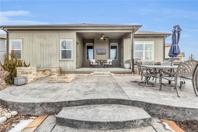 back of house with a ceiling fan, a patio area, and a fire pit