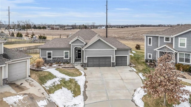 view of front of property featuring a garage, a shingled roof, fence, driveway, and stone siding