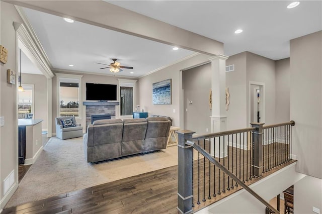 living room featuring dark wood-style floors, a fireplace, decorative columns, recessed lighting, and baseboards