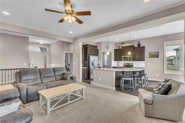 living room with recessed lighting, ornamental molding, light carpet, ceiling fan, and baseboards