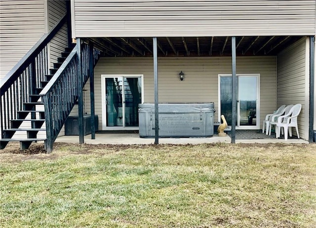 back of house with a yard, a patio, and a hot tub