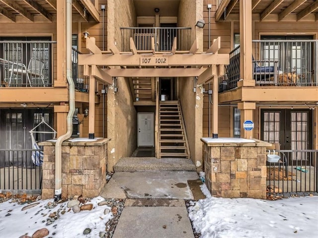 snow covered property entrance featuring french doors