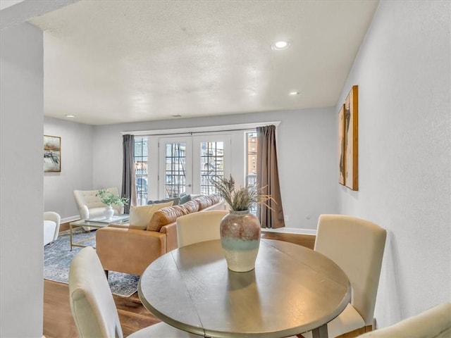 dining space with recessed lighting, light wood-style flooring, baseboards, and french doors