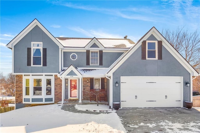 view of front of house featuring a garage, stucco siding, and brick siding