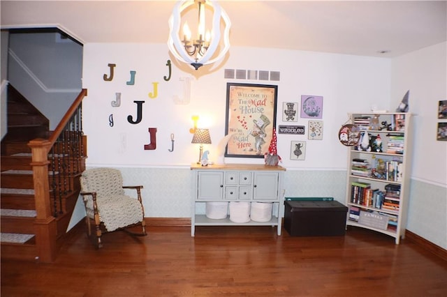 living area with a wainscoted wall, stairs, visible vents, and dark wood-style flooring