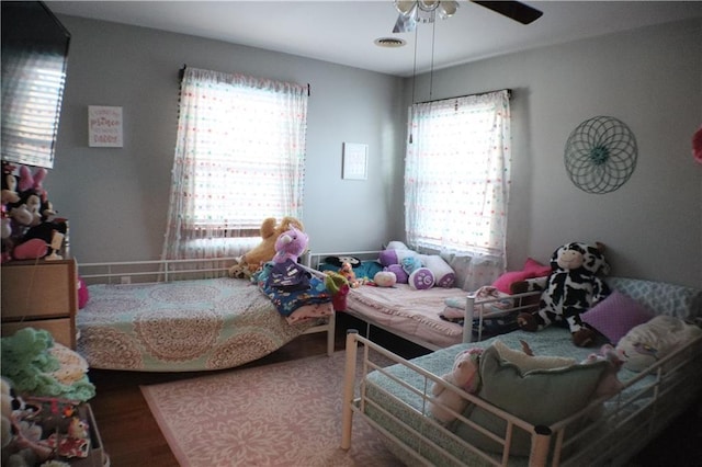 bedroom featuring ceiling fan, wood finished floors, and visible vents