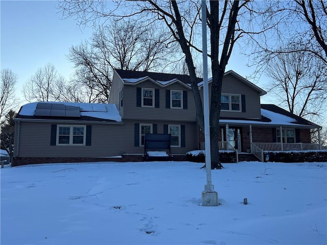 view of front facade with a porch and roof mounted solar panels