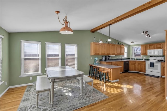 dining area featuring lofted ceiling with beams, light wood-style flooring, and baseboards