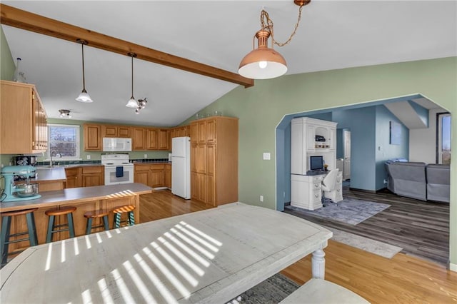 kitchen featuring lofted ceiling with beams, open floor plan, wood finished floors, white appliances, and a peninsula