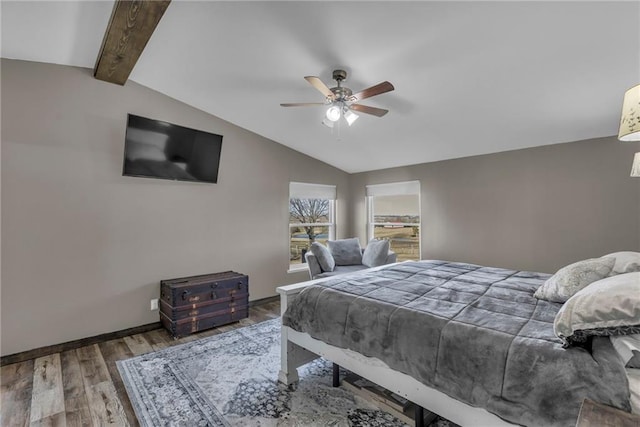 bedroom featuring vaulted ceiling with beams, wood finished floors, a ceiling fan, and baseboards