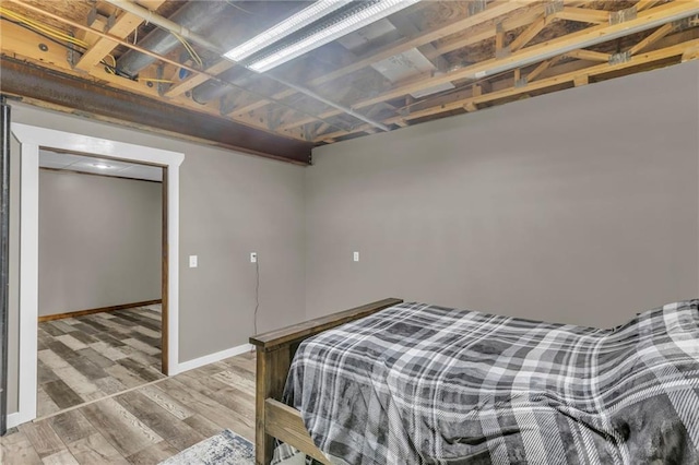 bedroom featuring wood finished floors and baseboards