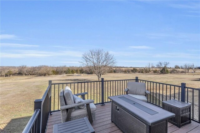 wooden deck featuring a rural view and a yard