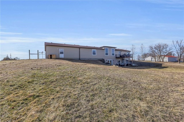 rear view of property with a lawn and a deck