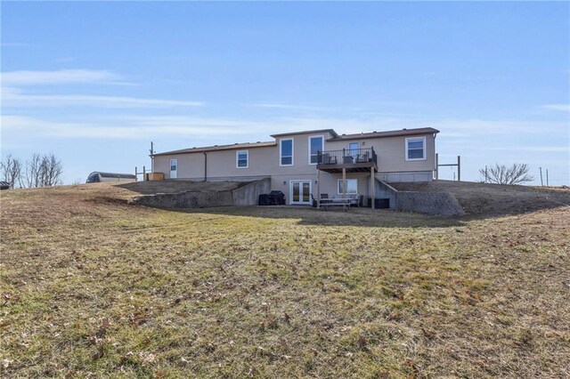 rear view of property with a yard, a deck, and french doors