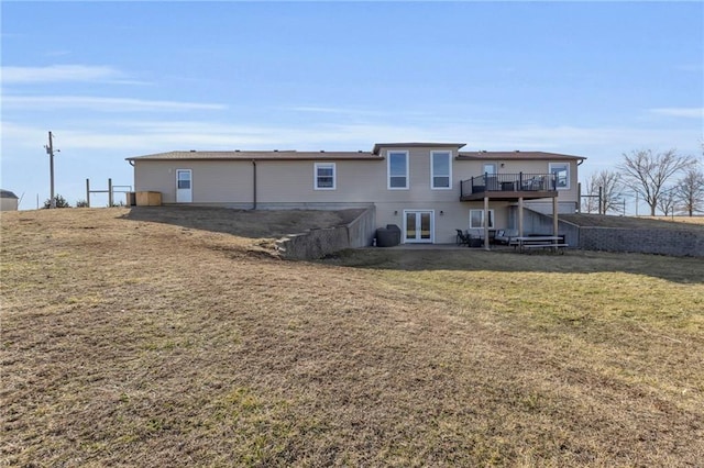 back of property featuring a yard, a deck, and french doors