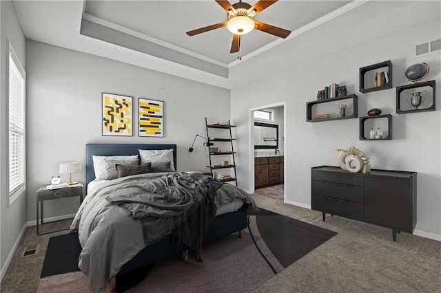 carpeted bedroom featuring visible vents, multiple windows, and a tray ceiling