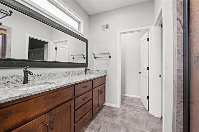 full bathroom featuring double vanity, baseboards, visible vents, and a sink