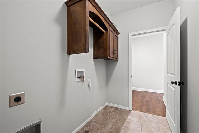 washroom with baseboards, cabinet space, hookup for an electric dryer, and washer hookup