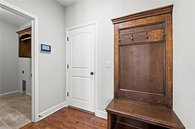 mudroom with dark wood finished floors and baseboards