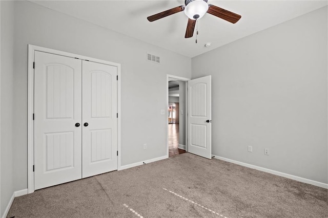 unfurnished bedroom with baseboards, visible vents, ceiling fan, a closet, and carpet flooring