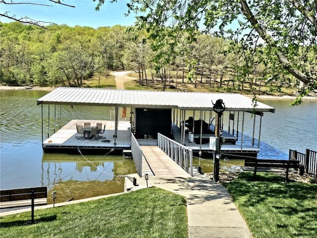 dock area with a water view, boat lift, and a yard