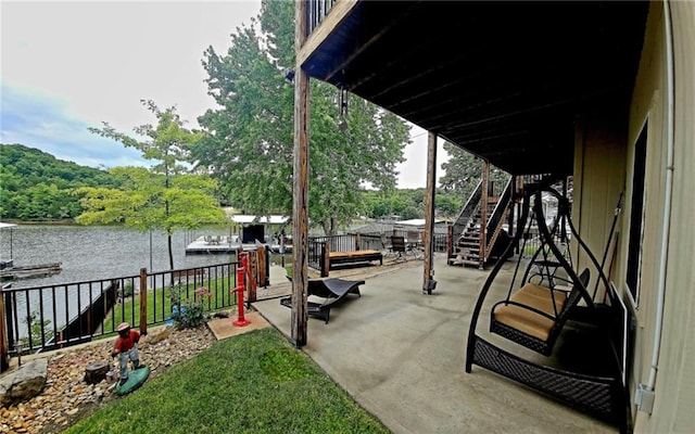 view of patio / terrace with stairs, a boat dock, and a water view