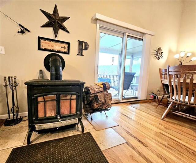 interior space featuring a wood stove, baseboards, and wood finished floors