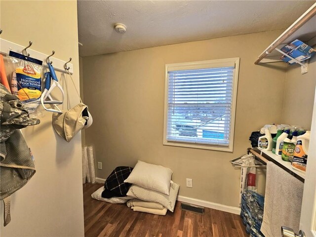 interior space with dark wood-type flooring, visible vents, and baseboards