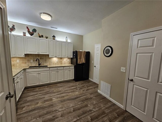 kitchen featuring dark wood finished floors, white cabinetry, a sink, and visible vents